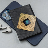 Lifetune Zone EMF protection device resting on a phone and wallet, surrounded by AirPods, highlighting its sleek design and portability.